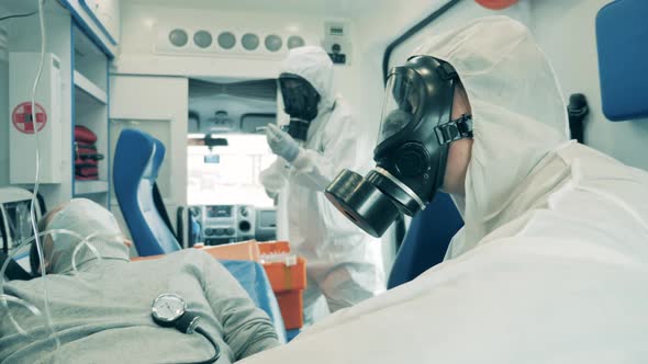 Two Doctors Are Riding in an Ambulance with a Male Patient alt