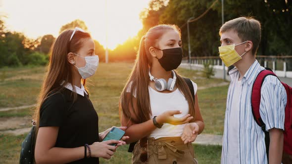Communication of Three Teenagers in Protective Masks alt
