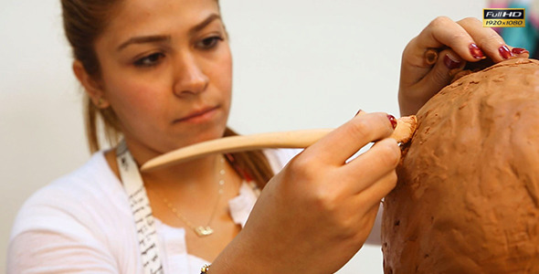Woman Working On Clay Sculpture in Art Class alt