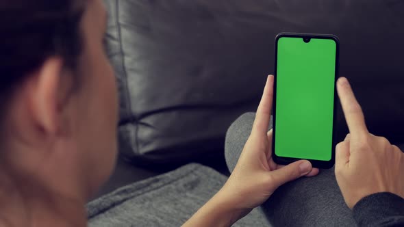 Female with green screen display smart phone in hand 4K footage