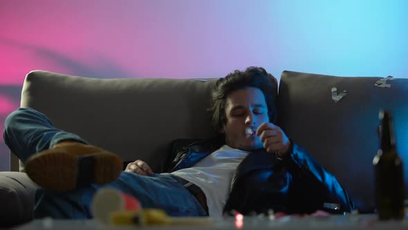 Drunk Man Lighting Cigarette, Smoking and Relaxing on Sofa