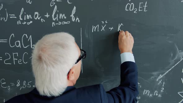 Back View of Smart Senior Professor Writing Equations on Chalkboard in ...