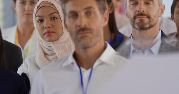 Female audience member at a business conference asking a question alt