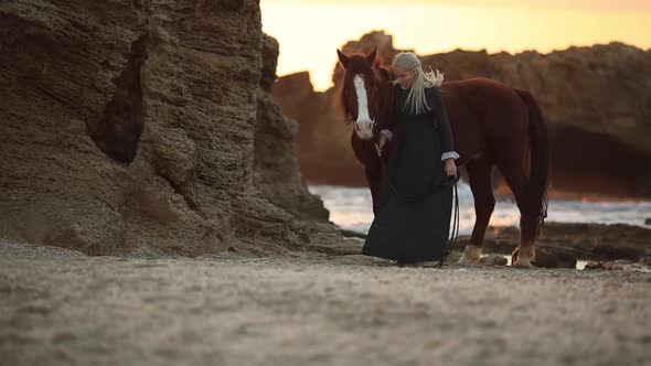 Woman with Horse on Rocky Seashore