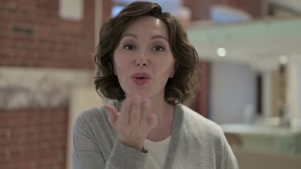 Portrait of Beautiful Old Woman Giving Flying Kiss alt