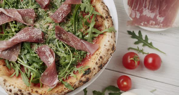 Delicious Pizza with Prosciutto Parma Ham Arugula Salad Rocket with Ingredients alt