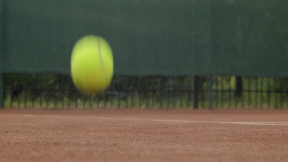Close Up Shot of Yellow Tennis Ball Jumping on Clay Court Slow Motion