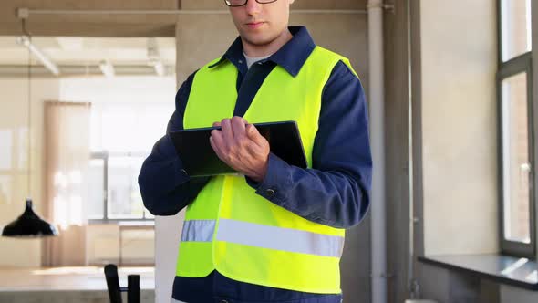 Builder in Helmet and Safety West with Tablet Pc alt