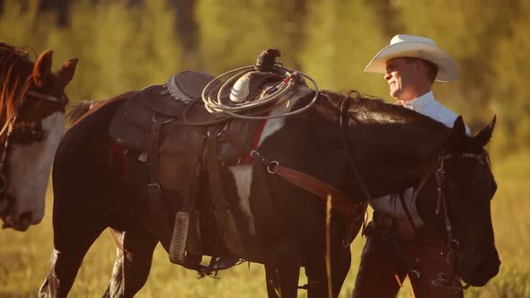 Group of cowboys saddle up and prepare for ride alt
