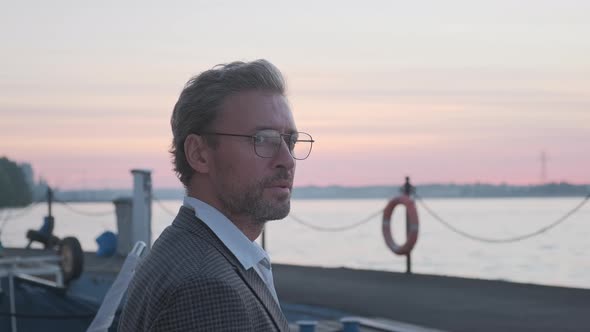Handsome Good-looking Mature Business Man at Yacht Pier in Marina at Sunset. alt
