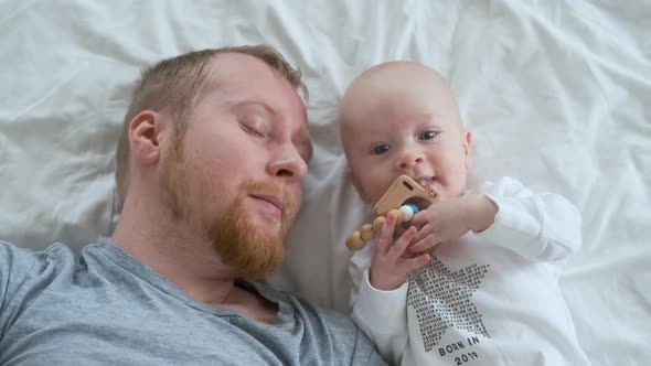 joyful kid playing with a rodent while lying next to dad