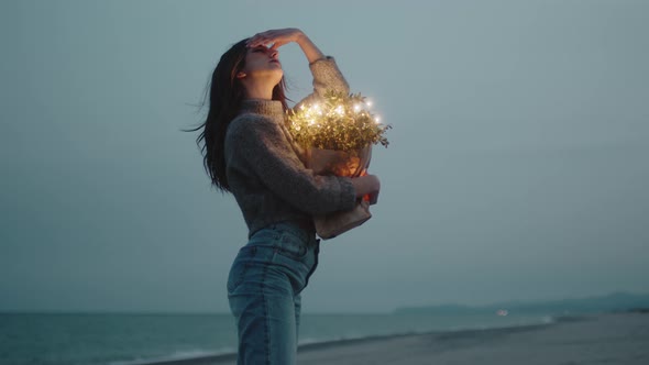 Happy Young Girl Enjoys Life on the Beach with Colorful Lights on Bag alt