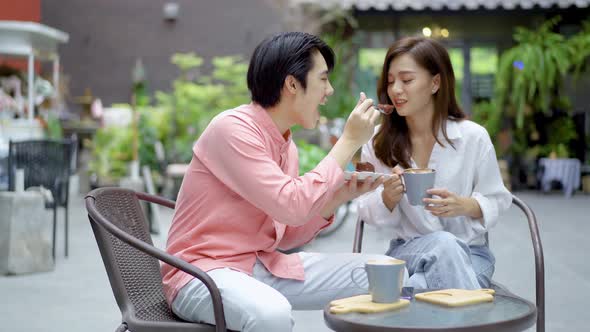 Man offers his girlfriend a bite of his cake, and then eats it himself as a joke, they both laugh alt