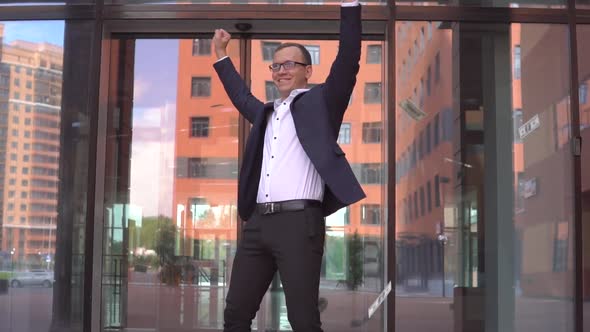 Rich Attractive Businessman in Glasses Picks Up Money and Rejoices alt