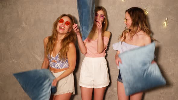 Pillow Fight. Sexy Women Having Fun At Party. Beautiful Smiling Female Models In Stylish Clothes 