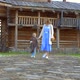 A Woman and Her Daughter are Walking in the Yard of an Old Wooden House - VideoHive Item for Sale
