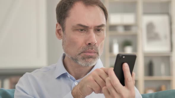 Senior Aged Businessman Using Smartphone Typing Message alt