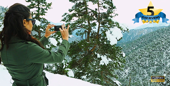 Young Woman Photographing Winter Landscape alt