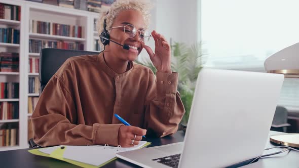 Young African American Woman Works Consults People Using Headset with Microphone alt