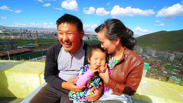 Mongolian Family, Ulaanbataar Is At Background