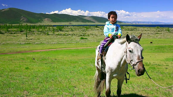 Young Baby Girl On Horseback In Steppe