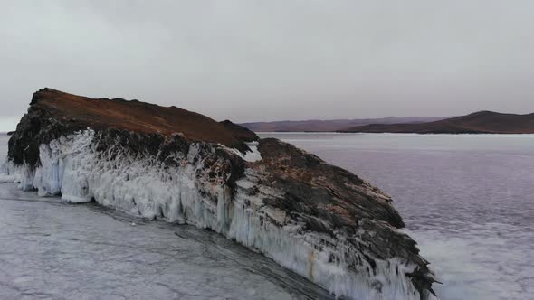 Rocks Covered with Ice Over a Frozen Lake. alt