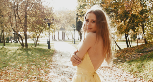 Woman In Yellow Dress Walking In The City Park