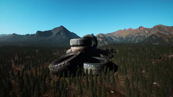 Concept of Environmental Pollution with Big Old Tires in Mountain Forest alt