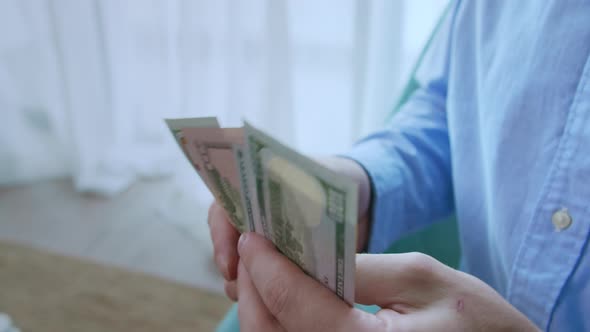 Man Gives 100 and 50 Dollar Bills From His Shirt Pocket Counts the Money Then Folds It in Half and alt