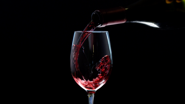 Red Wine Pouring In Wine Glass Over Dark Background Rose Wine