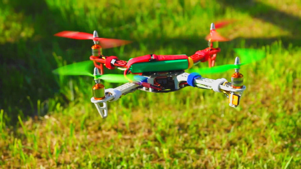 Quadcopter Drone Flies Over the Field