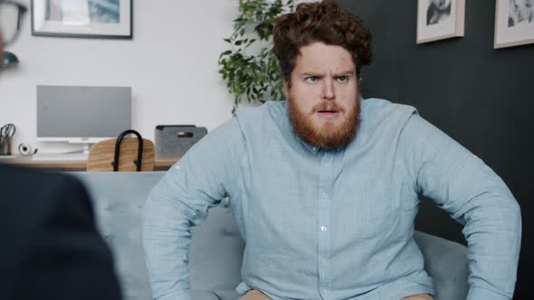 Agitated Guy Patient Speaking and Gesturing During Session with Psychotherapist Indoors in Office alt