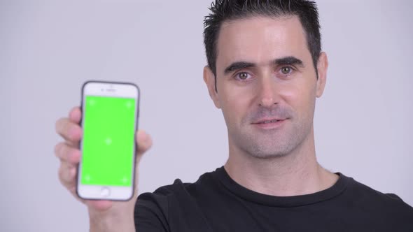 Face of Happy Handsome Man Smiling While Showing Phone alt