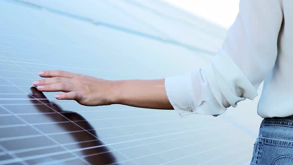 Close up of young woman engineer's hands touching solar panels. Solar energy. alt