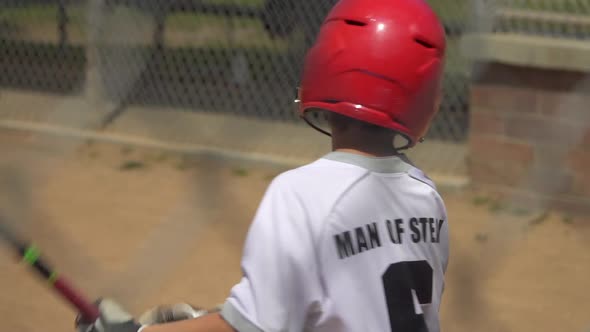 Boy at bat and batting in a little league baseball game. alt
