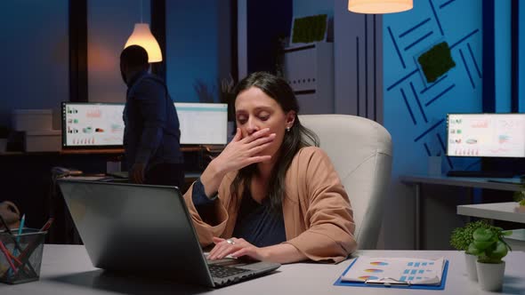 Exhausted Businesswoman Analyzing Marketing Statistics on Laptop Computer alt