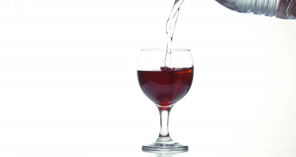 Water being poured into a Glass or Red Wine, against White Background, Slow motion 4K