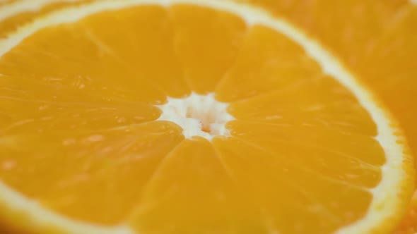 Sliced orange citrus fruit on the plate, close-up view, zooming motion