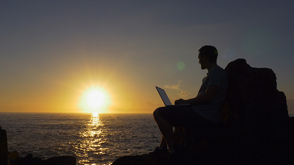 Sitting with a Laptop at Sunrise