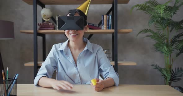 Asian Woman Wearing Virtual Reality Glasses and Rejoices Celebrating Birthday alt