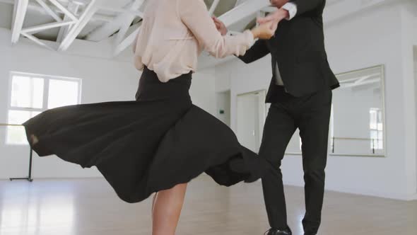 Caucasian senior couple spending time together dancing in a ballroom alt
