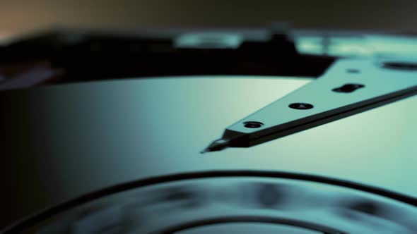 Close-up on the interior of the hard drive with working motor head reading data. alt