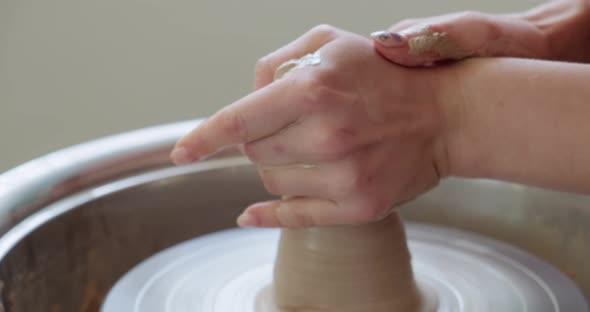 Female Potter Sitting and Makes a Cup on the Pottery Wheel. Woman Making Ceramic Item. Pottery alt