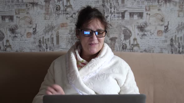 Old Woman in Glasses Having a Video Call on the Laptop Smiling and Talking Happily Indoors in a Cozy