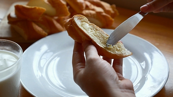 Spreading Butter on French Baguette