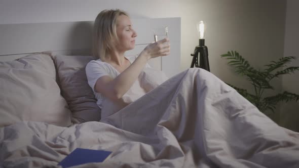 Attractive Woman Drinks Water Before Going to Bed alt