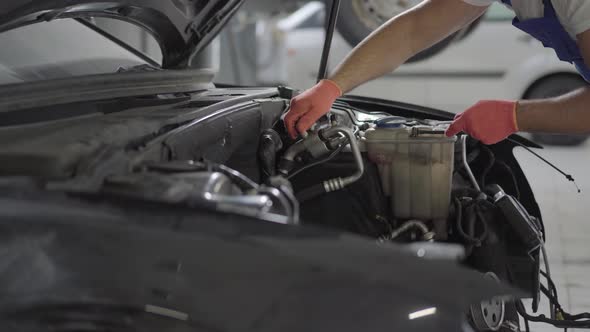 Hands of Mechanic Working Near Engine of the Car Tighten the Details with Fingers alt