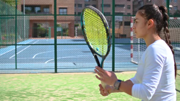 Young Woman Plays Tennis on the Field Close Up