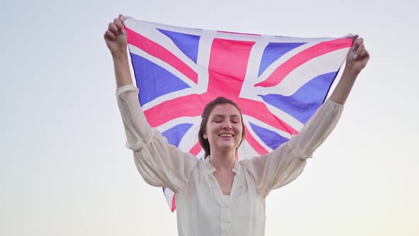 Happy Young Englishwoman with the British Flag. Independent Woman Patriot