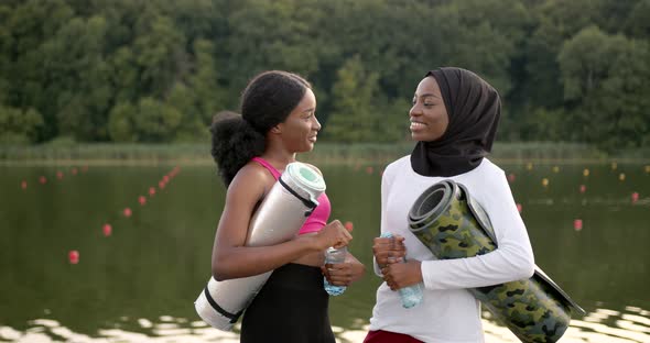 Female Friends with Sports Equipment Talking Outdoors alt